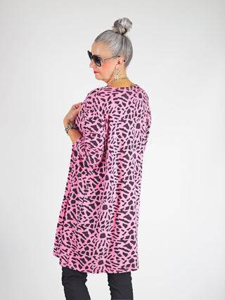 Das Bild zeigt das OFF#DLY Leo Set Raelle rosa, bestehend aus einem locker geschnittenen Top und einem passenden Long-Cardigan mit Schwarz-Weiß-Print, getragen von einer Frau.