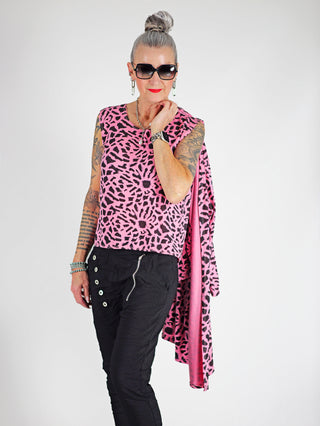 Frau mit Sonnenbrille und rosa Shirt trägt die OFF#DLY Pant Celeste black, schmale Jogginghose mit Gummibund und Zugkordel, sichtbar sind vordere Taschen und Knopfleiste.