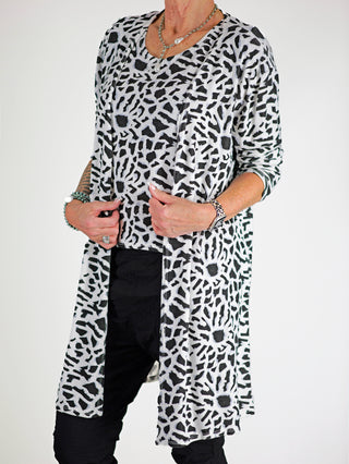 OFF#DLY Leo Set Raelle weiß: Frau trägt modisches Set mit lockerem Top und langem Cardigan im Schwarz-Weiß-Print, kombiniert mit Accessoires. Ideal für eleganten oder lässigen Look.