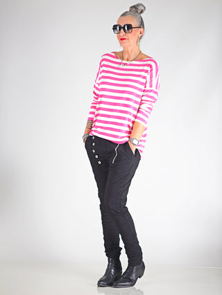OFF#DLY Ringel Grosso white/pink Langarmshirt, getragen von einer Frau mit Sonnenbrille, locker geschnitten, Rundhalsausschnitt, und langen Ärmeln, kombiniert mit schwarzen Hosen.