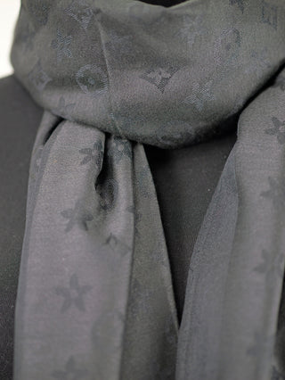 Nahaufnahme des OFF#DLY Schal Colette black, einem eleganten schwarzen Schal mit dezentem Muster, gefertigt aus weicher Viskose-Baumwollmischung, ideal für stilvolle Kombinationen und mit feinen Fransen verziert.