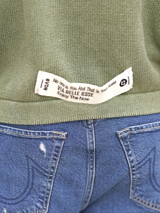 #VDR Pulli olive mit Kapuze zeigt strukturiertes Strickmuster, Kängurutasche und Label-Patch auf Rückseite. Der Oversize-Schnitt verleiht einen lässigen Look. Perfekt für entspannten Streetstyle.