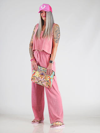 Frau in einem Dirty Laundry Towel Top pomegranate, ein kastig geschnittenes, verkürztes Baumwoll-Frottee-Top, das für einen lässigen, modernen Look sorgt, mit weiten Armausschnitten und elastischen Bündchen.