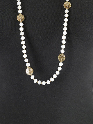 OFF#DLY Glasperlen Kette / Münze auf einem Mannequin, zeigt eine beaded Halskette mit goldenen und weißen Perlen, verziert mit einem goldenen Medaillon mit Lebensbaum-Design.
