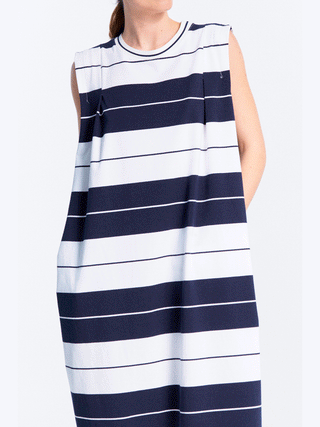 Frau trägt Lumina Dress Stripes blue, ein ärmelloses Maxikleid mit Streifenmuster. Weicher Baumwollmix, lockerer Schnitt, sportlicher Rundhalsausschnitt, ideal für warme Tage und vielseitige Looks.