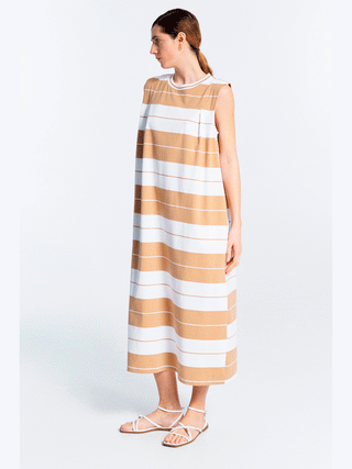 Frau in gestreiftem Lumina Dress Stripes caramel, ärmelloses Maxikleid mit maritimem Streifenmuster und rundem Halsausschnitt, präsentiert eine zeitlose Eleganz und moderne Lässigkeit.
