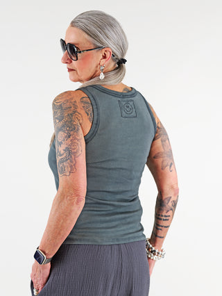OFF#DLY Top Neve wash black, getragen von tätowierter Frau mit grauen Haaren und Sonnenbrille; lässiges Baumwolltop mit Smiley-Patch, sportlichem Rundhalsausschnitt und vielseitiger Passform.