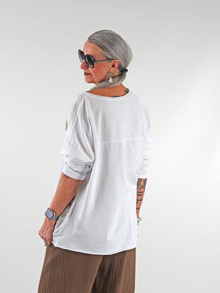 OFF#DLY Tee STAR white: Frau trägt weißes Oversize-Shirt mit Stern-Print, weitem Rundhalsausschnitt und Tattoos sichtbar auf den Armen. Lässiger, urbaner Look, perfekt für entspannte Outfits.