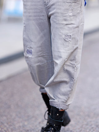 OFF#DLY Relax Fit Destroy Denim lightgrey, getragen von einer Person, zeigt einen lässigen Schnitt mit geradem Bein und Destroyed-Details, kombiniert mit schwarzen Stiefeln für einen urbanen Look.