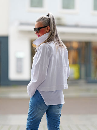 OFF#DLY Jacke Tiana white, getragen von einer Frau mit Sonnenbrille und weißem Shirt. Die Jacke zeigt einen boxy Oversized-Schnitt im Denim-Stil mit auffälligen Brusttaschen und Druckknöpfen.