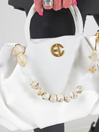 Enrico Coveri Tasche klein weiß: Elegante weiße Handtasche mit abnehmbarem Perlenhenkel und goldfarbenem Logo auf strukturierter Oberfläche, kompakte Größe, ideal für vielseitige Outfits.