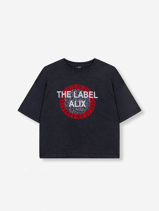 ALIX The Label Tee charcoal: Schwarzes Oversize-T-Shirt mit rotem Kreis und weißem Text „This is the label of an adventure“ auf der Vorderseite, aus weicher Baumwolle und geradem Schnitt.