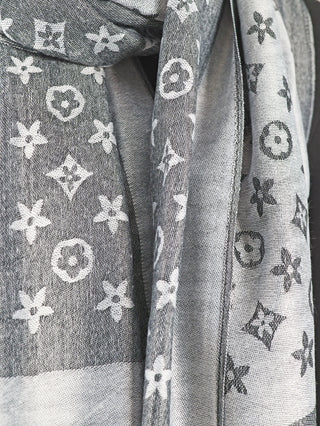 OFF#DLY Schal Colette grey: Nahaufnahme eines eleganten grauen Schals mit dezentem Muster und feinen Fransen, aus 80% Viskose und 20% Baumwolle, ideal für vielseitige Outfits.