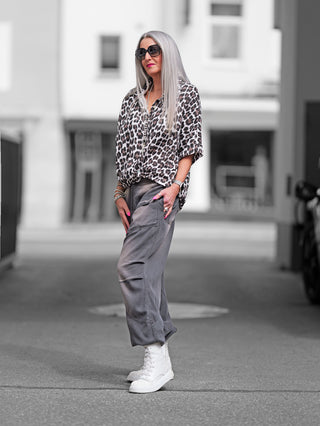 OFF#DLY Bluse Musselin Liora Leo black/white – Frau mit grauen Haaren trägt eine schwarz-weiße Leo-Muster-Bluse mit Knopfleiste und Kragen, lässig geschnitten für Bewegungsfreiheit und Komfort.