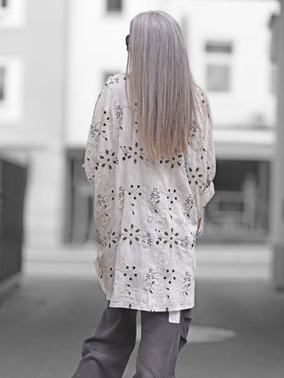 OFF#DLY Longbluse Stick beige black, oversize geschnitten mit kunstvollen schwarzen Stickereien. Die Bluse zeigt eine natürliche fließende Struktur, ideal für stilbewusste Frauen, die Eleganz und Komfort schätzen.
