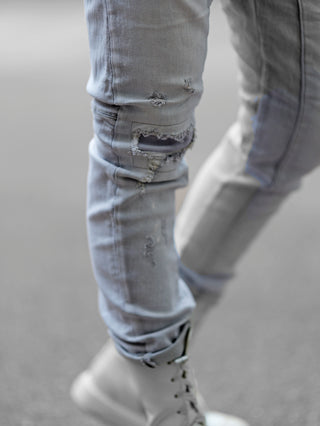 Person trägt OFF#DLY Destroy Denim Zelda lightgrey, zerrissene Jeans mit unterlegtem Stoff, moderner Fit, bequemes elastisches Material. Perfekt für urbanen Style mit Sneakern oder Boots.