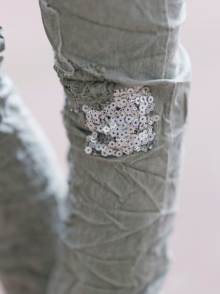 Nahaufnahme der OFF#DLY Pant Vesper khaki mit auffälligen Pailletten- und Stoffpatches, die dem lässigen Crinkle-Look der Jogpant Glanz verleihen. Ideal für Frühling und Sommer.
