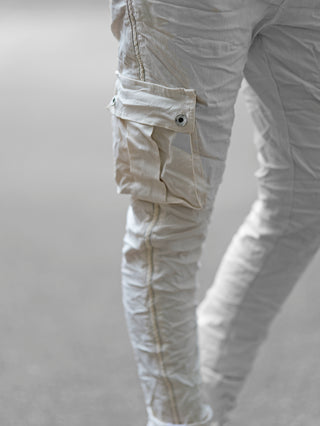 Die OFF#DLY Pant Corinna Cargo Vanilla zeigt sich im modischen Utility-Style mit Beintaschen, Crinkle-Look, elastischem Bund und seitlichem Glitzerband. Perfekt für einen vielseitigen, urbanen Look.