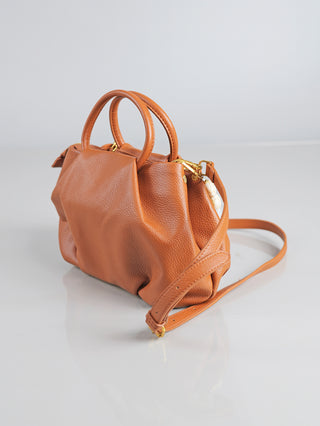 Enrico Coveri Tasche klein camel, eine elegante Handtasche aus braunem Kunstleder mit abnehmbarem Tragehenkel und verstellbarem Schulterriemen, auf einer weißen Fläche präsentiert.