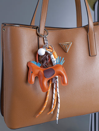 OFF#DLY Taschenanhänger Horse orange, ein brauner Ledergeldbeutel mit einem auffälligen Pferde-Schlüsselanhänger. Kompakte Größe, stilvolles Accessoire mit Logo-Detail und stabilem Verschluss.