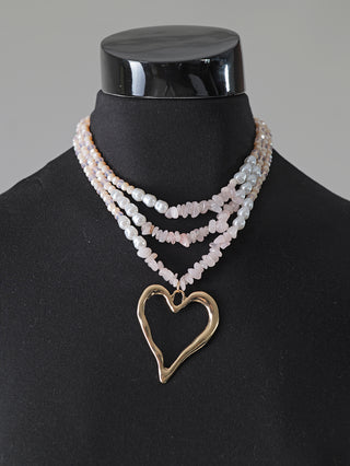 OFF#DLY 3 Strangkette Heart rose/gold auf einer Schaufensterpuppe, zeigt eine Kette mit einem herzförmigen Anhänger. Hergestellt aus hochglanzbeschichtetem Kupfer, Glas und Kunststoff. Länge: 24 cm, Anhänger: 6 cm.