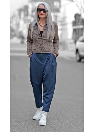 OFF#DLY Denim Jacket Marrone, getragen von einer Frau mit langen grauen Haaren, blauer Hose und Sonnenbrille, zeigt den lässigen Denim-Stil mit schmaler, gerader Passform.