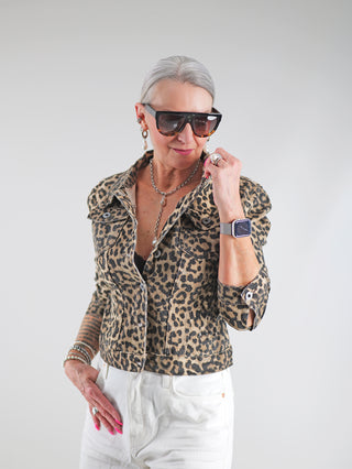 Frau trägt die OFF#DLY Denim Style Jacke Leo mit Leopardenmuster, figurbetontem Schnitt und Brusttaschen. Kombiniert mit Sonnenbrille, die Jacke betont die Taille und bietet stilvolle Vielseitigkeit.