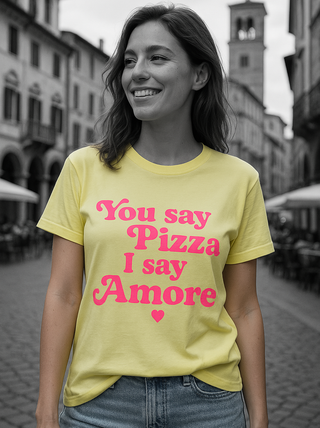 Frau trägt das OFF#DLY Tee Pizza/Amore in Gelb mit pinkem Print You say Pizza – I say Amore, rundem Halsausschnitt und lässigem Schnitt, italienisch gefertigt.