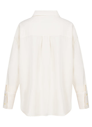 Gitta Banco Bella Bluse ecru, eine weiße, langärmelige Bluse mit Oversized-Fit und Hemdkragen aus 100 % Tencel, präsentiert sich mit Knopfleiste und verlängertem Rückenteil als vielseitiges Kleidungsstück.