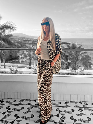 Frau trägt OFF#DLY Musselin Pant Leo black/white: luftige, weite Hose mit Leopardenmuster, elastischem Bund und Seitentaschen, ideal für entspannte oder stilvolle Outfits.