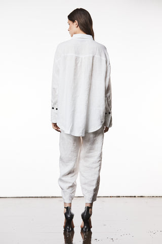 Thom Krom Bluse WH18 offwhite, locker sitzendes Langarmhemd aus Baumwoll-/Leinenmix, mit langen Manschetten und abgerundetem Saum, getragen von einer Frau, kombiniert mit schwarzen High Heels.