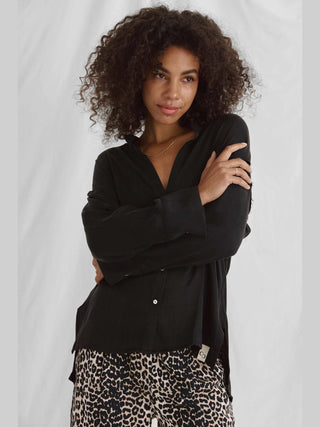 Cotton Candy Iken Bluse black: Oversized Bluse mit Stehkragen und Saumversatz, aus fließendem Material, getragen von einem Modell mit 1,76 m, in Größe S.