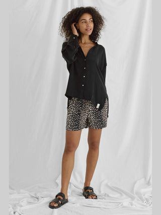 Die Cotton Candy Iken Bluse black ist eine lässige, fließende Bluse mit Stehkragen und Saumversatz, oversized Passform und maschinenwaschbar bei 30°C. Ideal für einen entspannten Look.