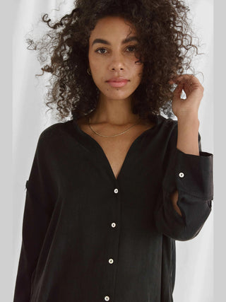 Die Cotton Candy Iken Bluse black zeigt sich in einem lässigen, fließenden Design mit Stehkragen und Saumversatz, oversized Passform, ideal für vielseitige Looks.