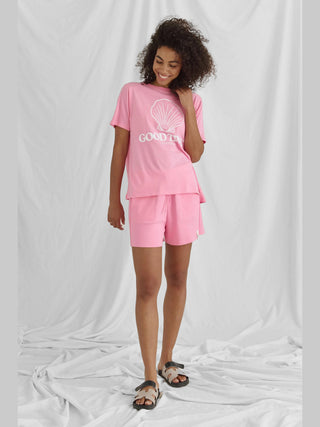 Das Cotton Candy Tee Azra pink ist ein weiches T-Shirt mit Rundhalsausschnitt und Rückenwrap, verziert mit dem Frontprint GOOD TIMES, getragen in regulärer Passform.