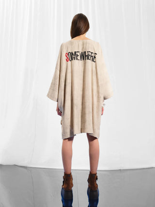 Eine Frau trägt die #VDR Tunica beige, eine oversized Tunika mit weitem Schnitt, halblangen Ärmeln und einem auffälligen Rückenprint. Perfekt für einen entspannten, modernen Look.