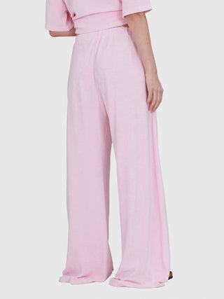 Person trägt True Religion Wide Leg Pant Frottee pink a boo mit weitem Schnitt, elastischem Bund und Eingrifftaschen, betont durch den weichen Frotteestoff und die entspannte Passform.