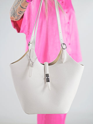 Diana & Co Firenze Bag vanille: Person hält eine weiße, elegante Tasche mit Magnetverschluss und herausnehmbarer Innentasche, passend für den Alltag und vielseitige Anlässe.