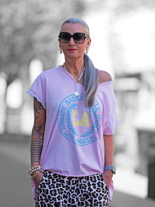 Oversize-T-Shirt OFF#DLY Tee Ronja rosa mit „LA“-Frontprint, rundem Halsausschnitt, kurzen Ärmeln mit offener Saumkante und lässigem, weichem Baumwollmix.