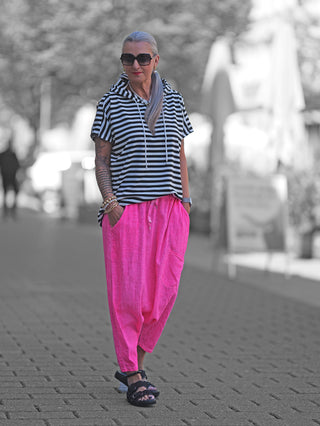 Frau in Streifenshirt trägt OFF#DLY Harem Pant Leyla pink mit Taschen und flexiblem Bund, kombiniert mit Sandalen.