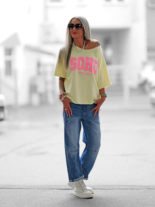 SOHO-Sweatshirt in Buttergelb mit Oversize-Schnitt, SOHO New York-Print, weitem Rundhalsausschnitt und halbarmen Design. Perfekt für urbane Looks, aus Baumwoll-Polyester-Mix, ideal bis Größe 42.