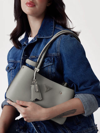 Guess Meridian Shoulder Satchel IVO aus Kunstleder mit hellgoldfarbenen Metallteilen, Reißverschluss, Nieten-Details und abnehmbarem Logo-Charm. Maße 27x17x9 cm, zwei Henkel, Metallemblem vorne.