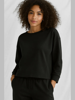 Langarmshirt Cotton Candy Tee Nora black mit Rundhalsausschnitt, offenen Kanten und Rückendetail. Oversized-Passform, getragen von einer 1,76 m großen Person in Größe S. Material: 100% Baumwolle.