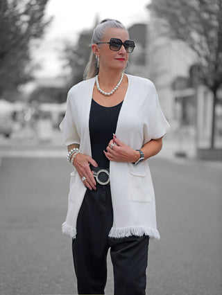 Die OFF#DLY Strickjacke Sabrina creme zeigt eine feine Jacke ohne Knopfleiste, mit seitlichen Taschen und Fransen am Bund. Sie ist in Einheitsgröße erhältlich und passt bis Größe 44.