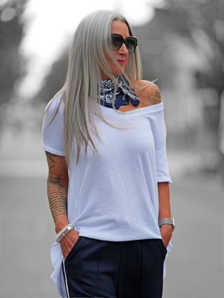 Weißes OFF#DLY Shirt Luisa mit Oversize-Schnitt, überschnittener Schulter und asymmetrischem Saum, aus Baumwolle-Elasthan-Mix. Perfekt für lässige Alltagslooks, sitzt leger und schmeichelt der Figur.