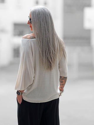 OFF#DLY Pulli Pisa offwhite, locker geschnitten mit 3/4-Fledermausärmeln und U-Boot-Ausschnitt, tragbar als off-shoulder. Hergestellt aus einem fließenden Viskose-Polyester-Elasthan-Mix für einen femininen Look.