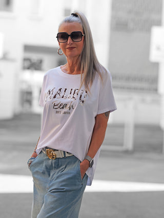 Das OFF#DLY Tee Malibu white zeigt einen lässigen Malibu Beach Est. 1996 Frontprint. Mit einem entspannten Schnitt verkörpert es einen coolen Beach-Vibe, ideal für einen stylischen, unkomplizierten Look.