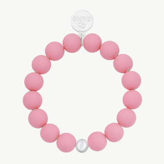OFF#DLY Armband rose mit etwa zwanzig matten rosa Acryl-Perlen, einem silberfarbenen Akzent-Perle und kleinem silbernem Logo-Charme. Elastisch, passt sich jedem Handgelenk an.