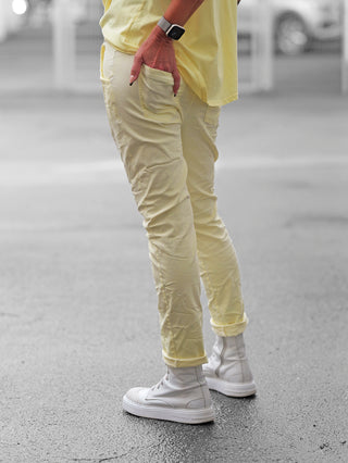 Nahaufnahme der OFF#DLY Pant Lennox butteryellow, eine lässige Jogpant in Beige mit sportlichem Gürtel, aufgesetzten Gesäßtaschen und modernem Crinkle-Look, ideal für entspannte, modische Outfits.