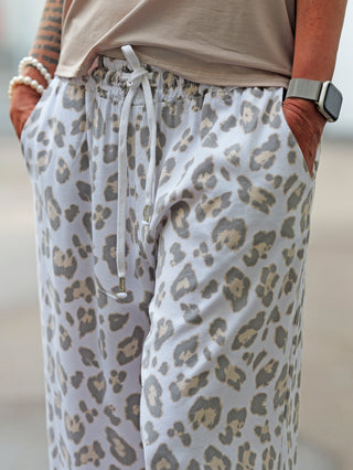Nahaufnahme der OFF#DLY Pant Pisa Leo white/grey mit weitem Schnitt und dezentem Leomuster, elastischem Bund und seitlichen Taschen, ideal für lässige Sommerlooks.